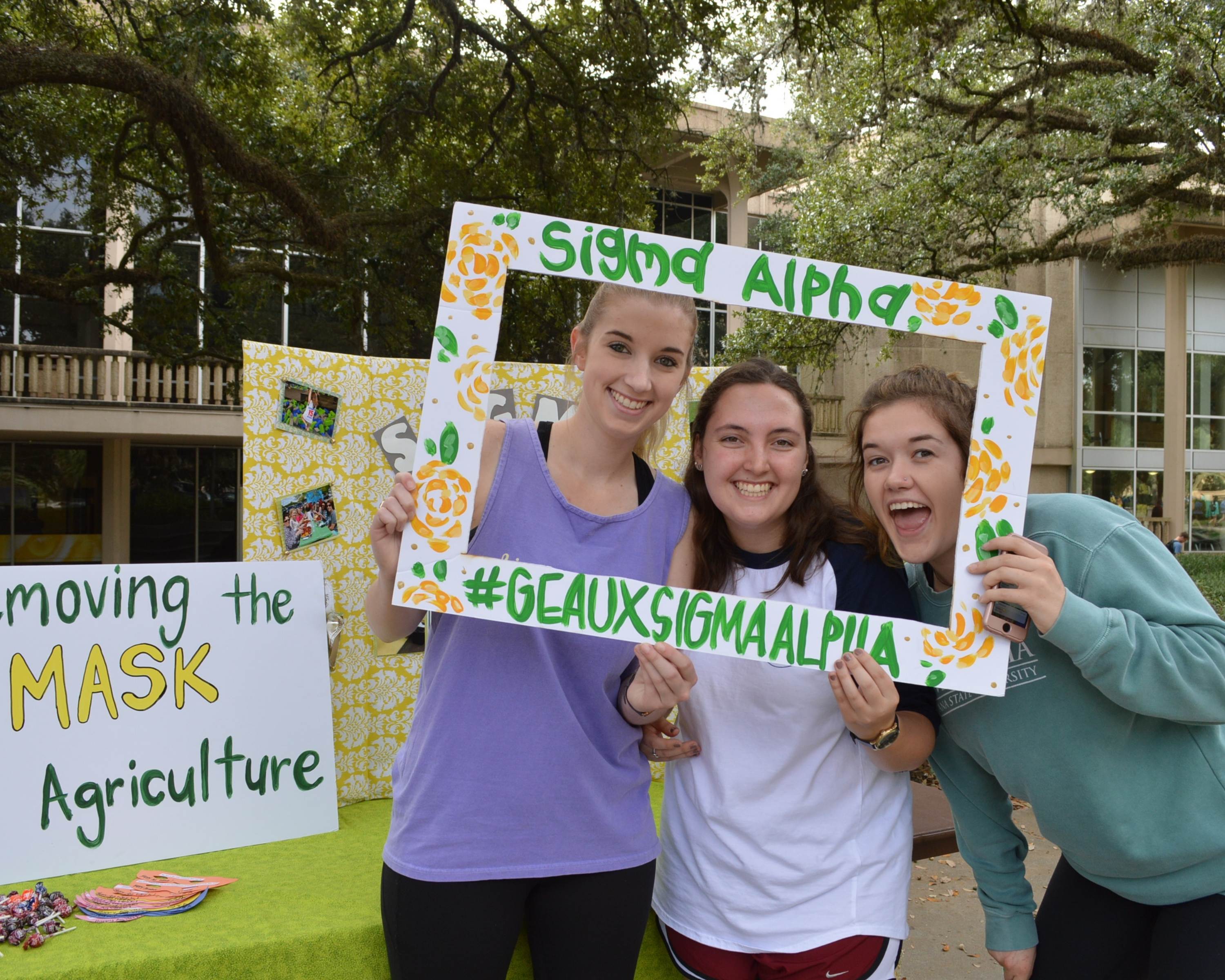 Students hold sigma alpha sign