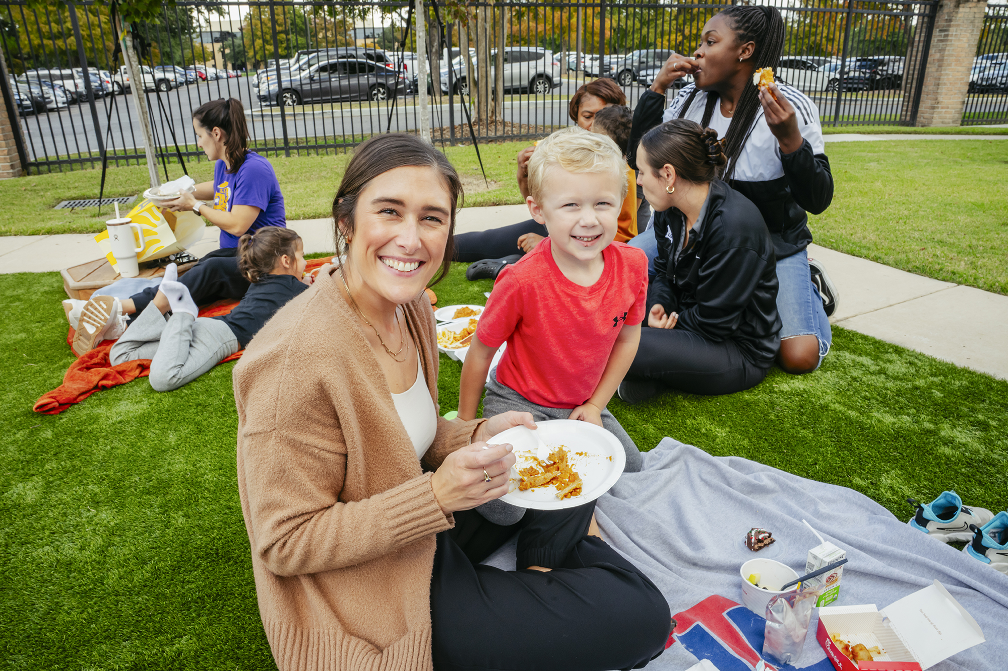 Mother and daughter sitting on blanket in grass