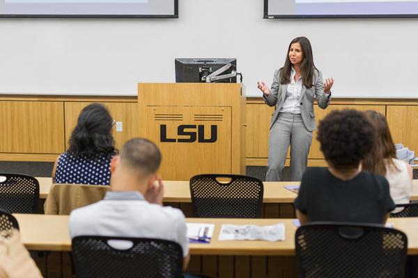 Suzy Caleo lectures at front of classroom 