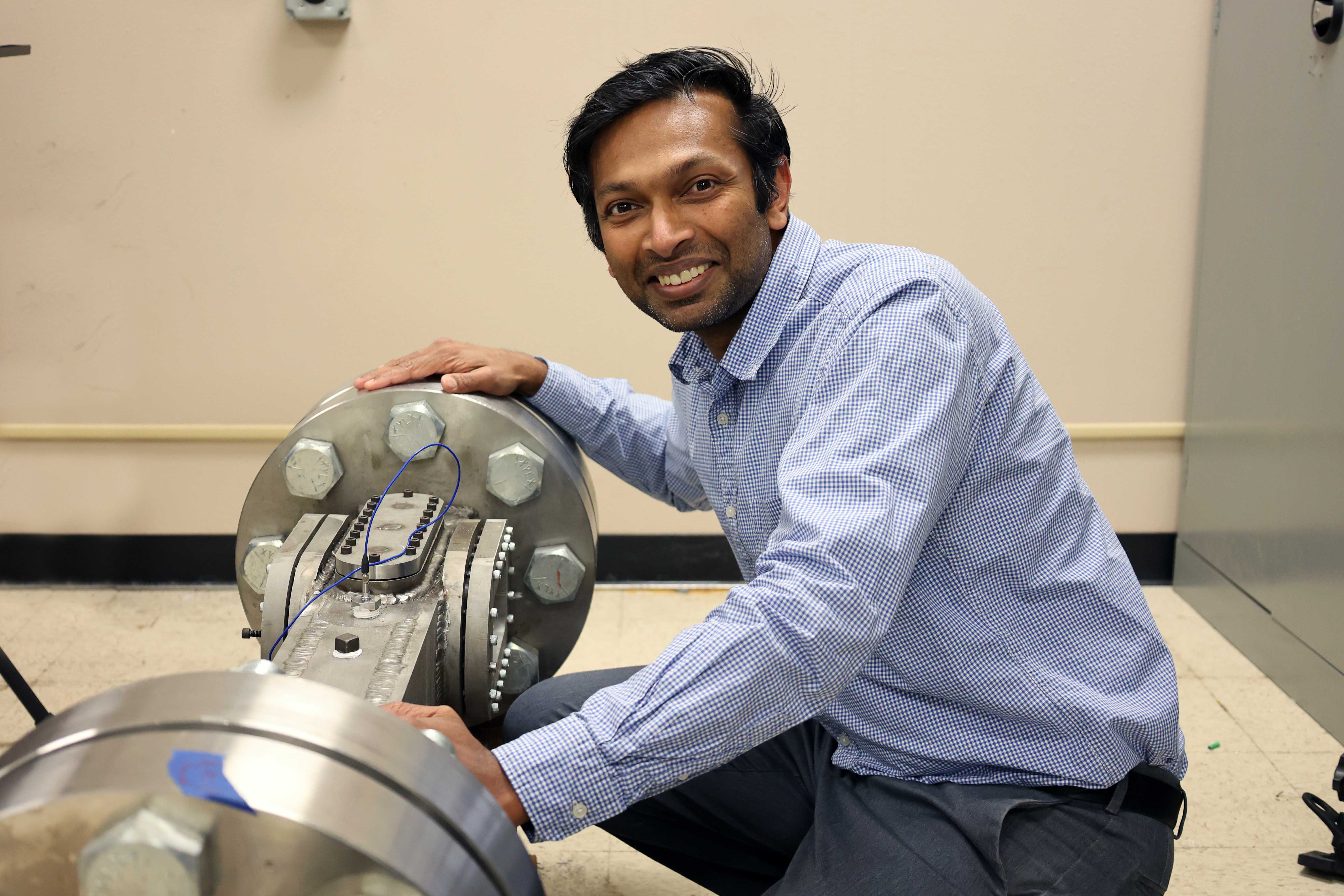 Image of Shyam Menon in lab with equipment.