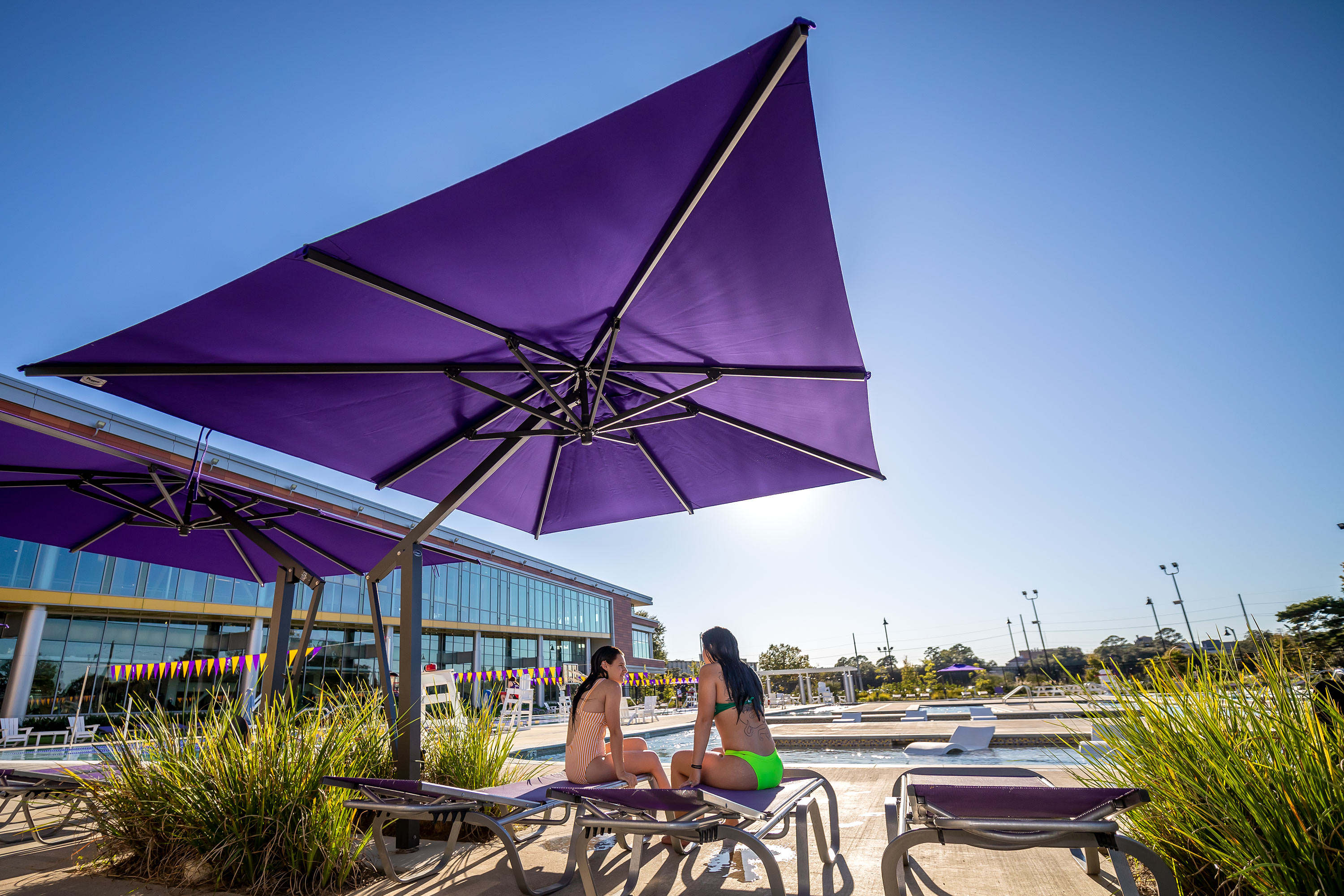 patrons lounging in the shaded area of our outdoor pool